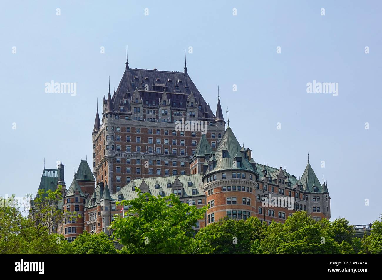 Majestätisches Hotel Château Frontenac mit ikonischen Türmen und Kupferdächern vor blauem Himmel Stockfoto