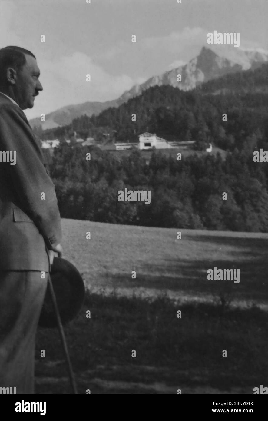 Adolf Hitler steht am Obersalzberg der Bayerischen Alpen bei Berchtesgaden. Im Hintergrund befindet sich der Berghof - Hitlers Haus Stockfoto