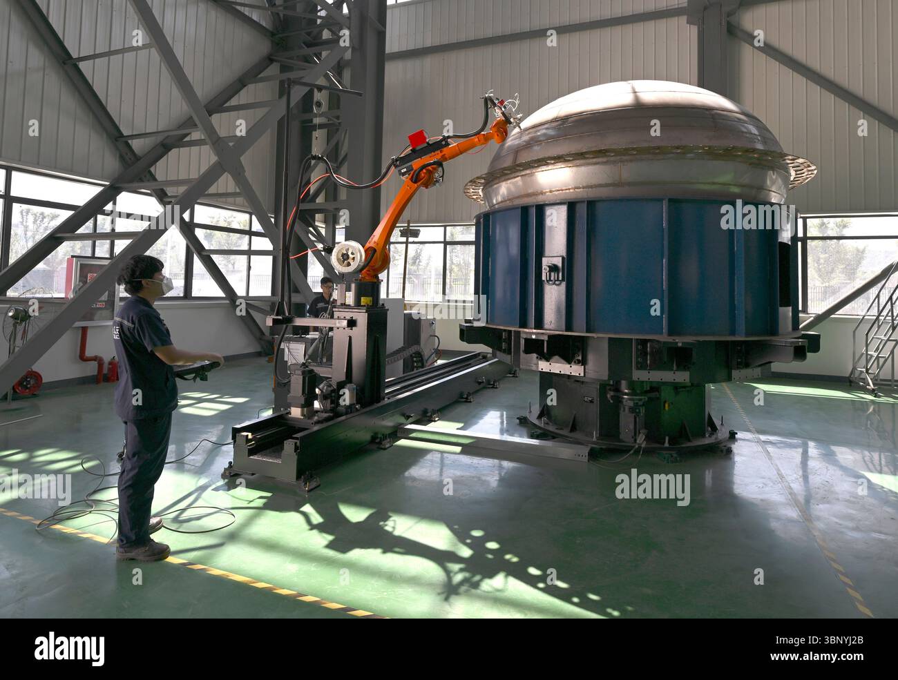 (250705) -- BENGBU, 5. Juli 2025 (Xinhua) -- Ein Mitarbeiter betreibt einen Schweißroboter, um den Boden eines Raketentanks in der Werkstatt des chinesischen privaten Raketenunternehmens Deep Blue Aerospace in der Stadt Bengbu in der ostchinesischen Provinz Anhui zu schweißen, 3. Juli 2025. In den letzten Jahren hat die Provinz Anhui das Layout ihrer Luft- und Raumfahrtinformationsindustrie beschleunigt, die Wirtschaft in geringen Höhen, kommerzieller Raum, Satellitenanwendungen und Tiefenweltraumforschung umfasst. Von der boomenden „Wirtschaft in geringer Höhe“ wie Drohnenlieferung und Tourismus in geringer Höhe bis hin zur Zusammenführung von Unternehmen zu einem kommerziellen Geschäft Stockfoto