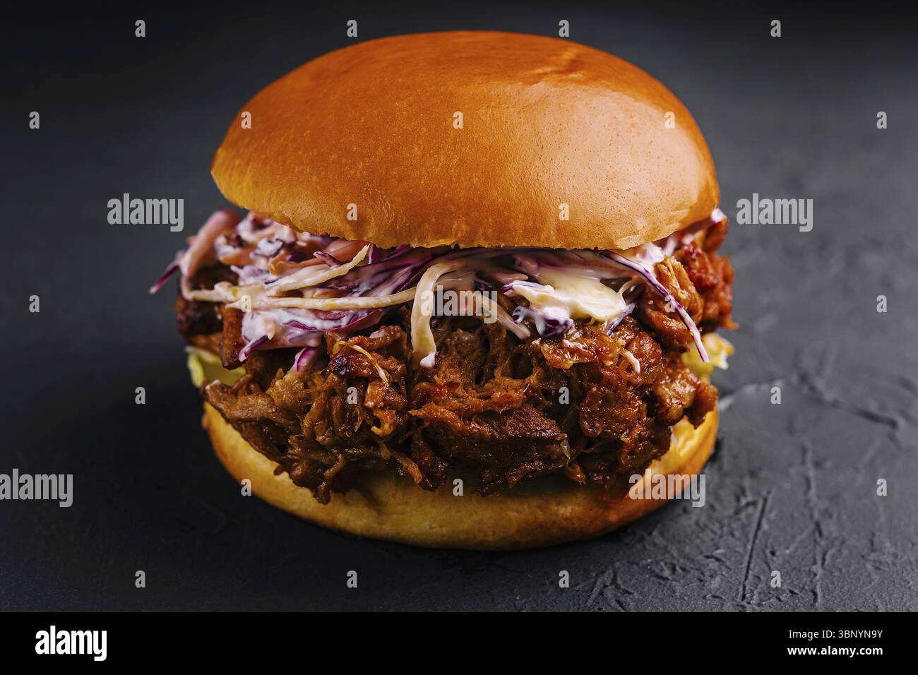 Essen Stillleben, Pulled Schweinefleisch Sandwich auf schwarzem Stein Stockfoto