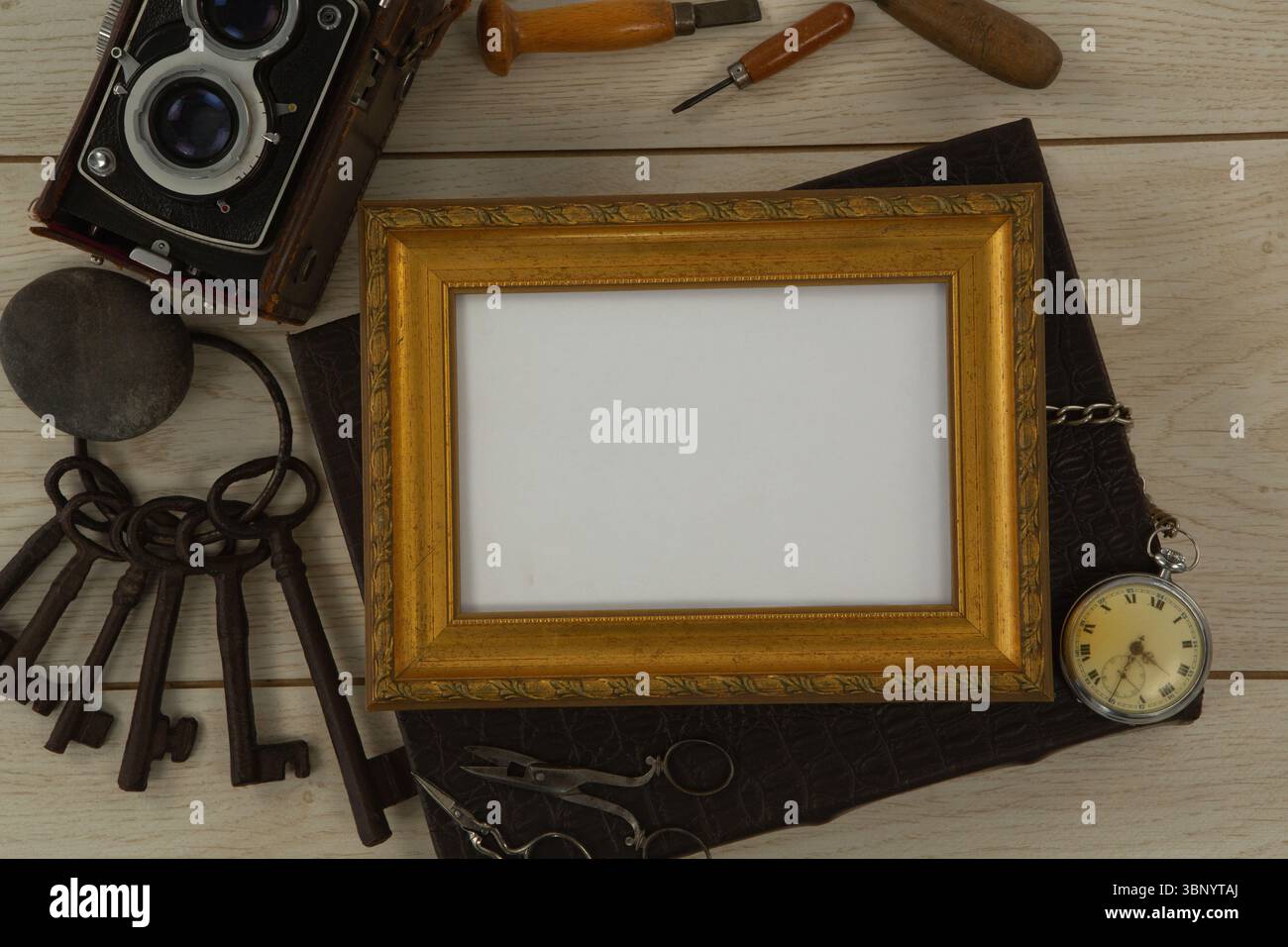 Bilderrahmen, Uhr, Schlüssel, Kamera auf Holztisch Stockfoto