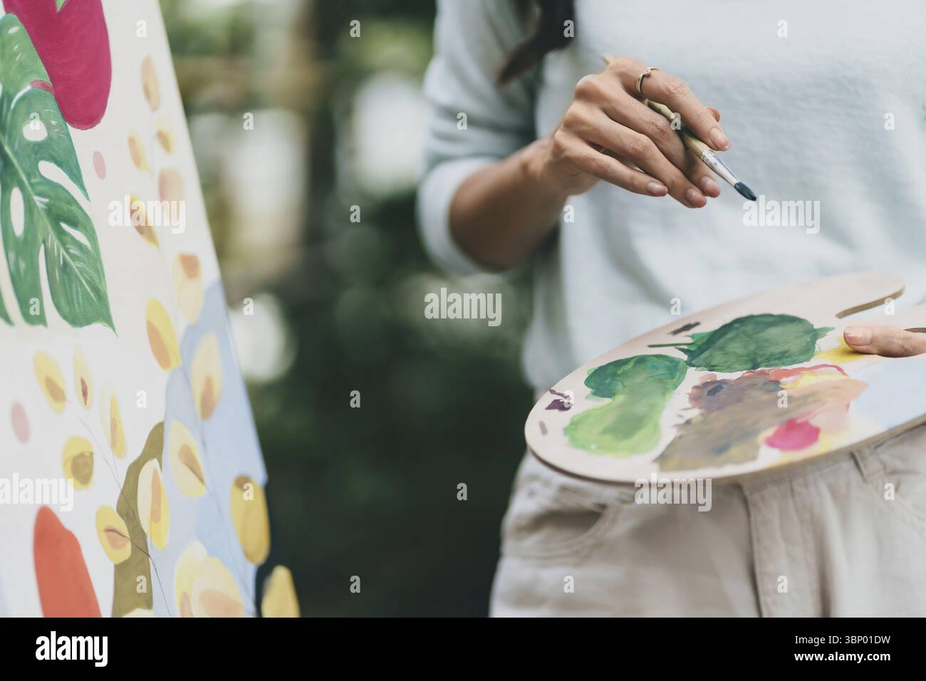 Weibliche Künstlerin malte Kunst Leinwandzeichnung mit Inspiration im Gartenkunsttherapie-Kreativkonzept Stockfoto
