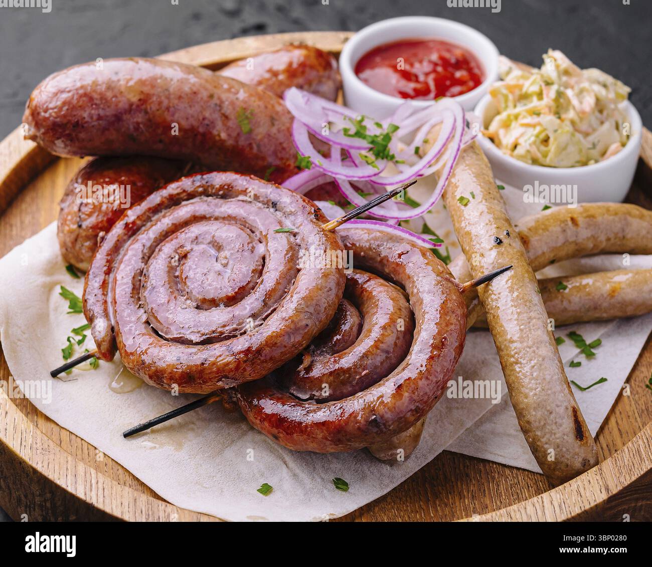 Gegrillte Würstchen auf einem Holzbrett mit Soße Stockfoto