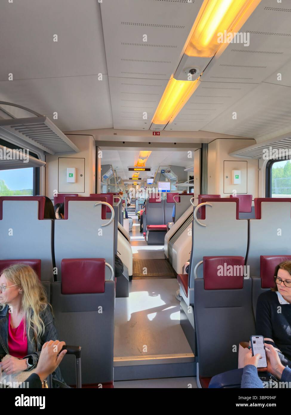 Passagiere im Zug zwischen dem Helsinki-Vantaa Airport und dem Hauptbahnhof in Helsinki, Finnland. - Smartphone-aufgenommenes Stockfoto