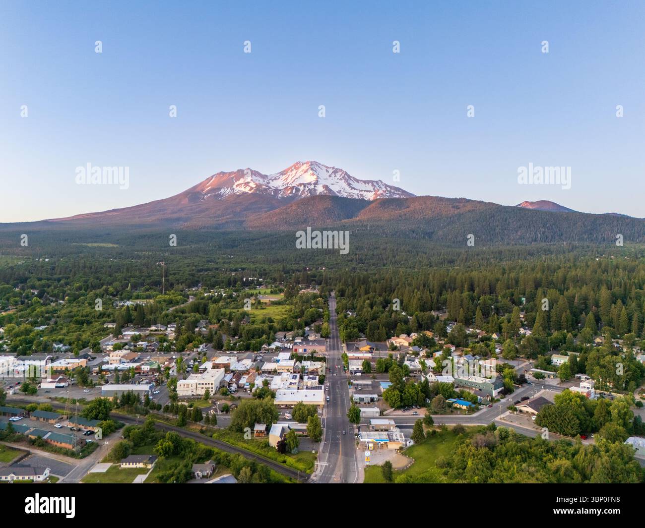 Mount Shasta Vulkan und Stadt, Kalifornien, USA, aus der Vogelperspektive bei Sonnenuntergang im Sommer Stockfoto
