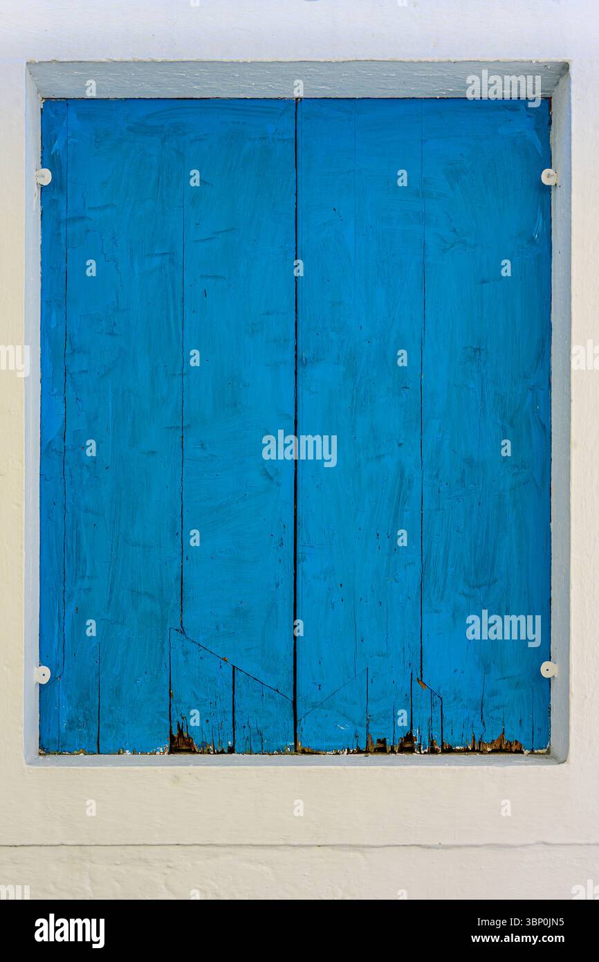 12-19/05/2025 Gaios, Paxos, Griechenland. Auffälliger Bluw Shutter, verrottet unten.© Simon Grosset Stockfoto