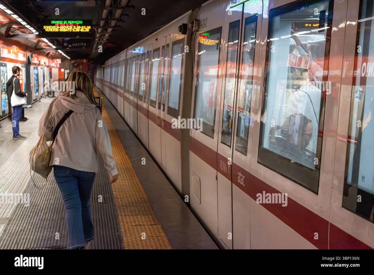 Passagiere, die auf dem Bahnsteig warten, wenn ein U-Bahn-Zug in Rom am Bahnhof ankommt und das moderne öffentliche Verkehrssystem der Stadt vorstellt Stockfoto
