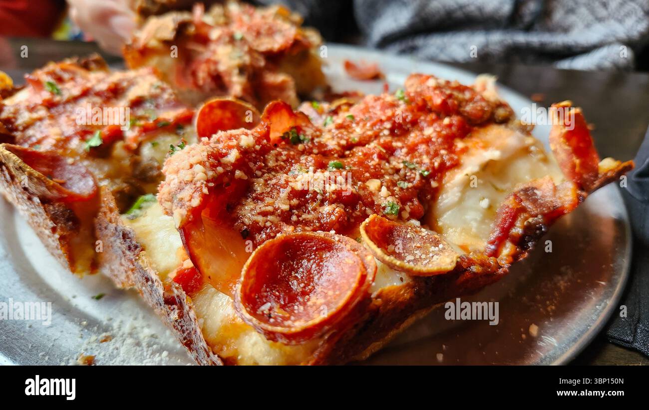 Nahaufnahme der knusprigen Pizzeria im Detroit-Stil mit Parmesan und Sauce Stockfoto