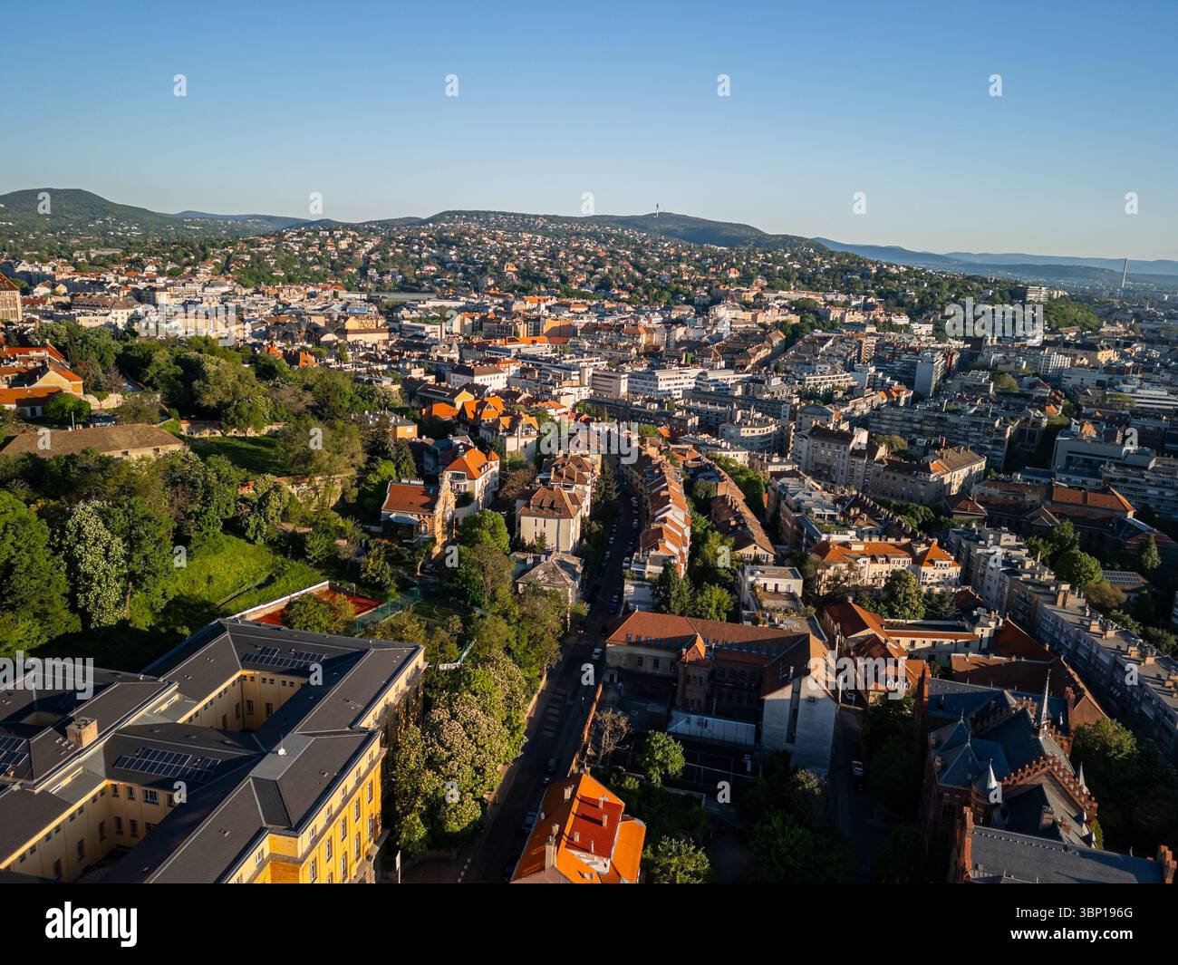 Drohnenfoto vom Burgviertel mit Blick ins Landesinnere über Buda Viertel, mit Dächern von Bezirk 1, Széll Kálmán tér, entfernten Hügeln von Distrikten 2 Stockfoto
