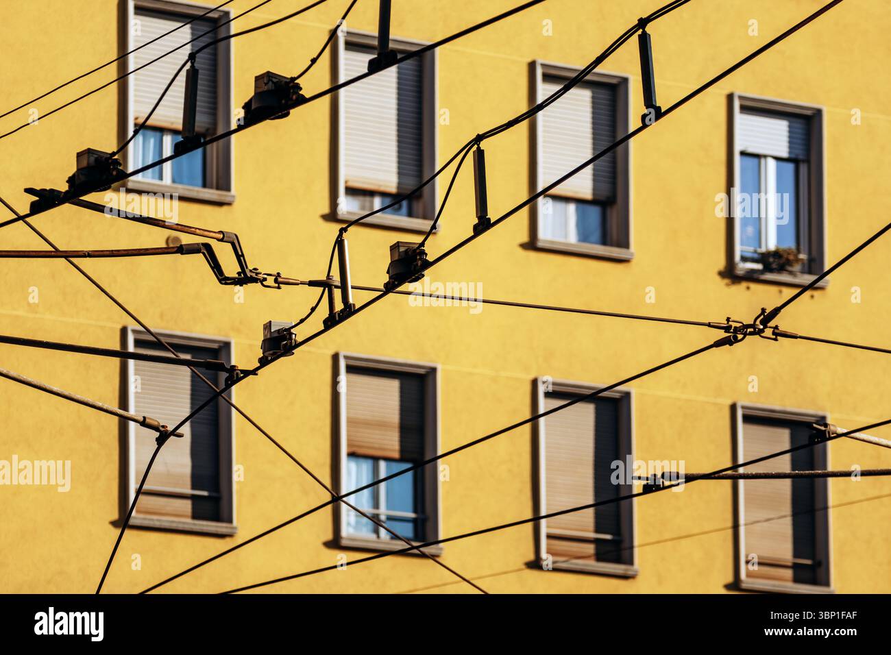 Straßenbahnkabel und gelbe Wohnfassade im Viertel Navigli in Mailand Stockfoto