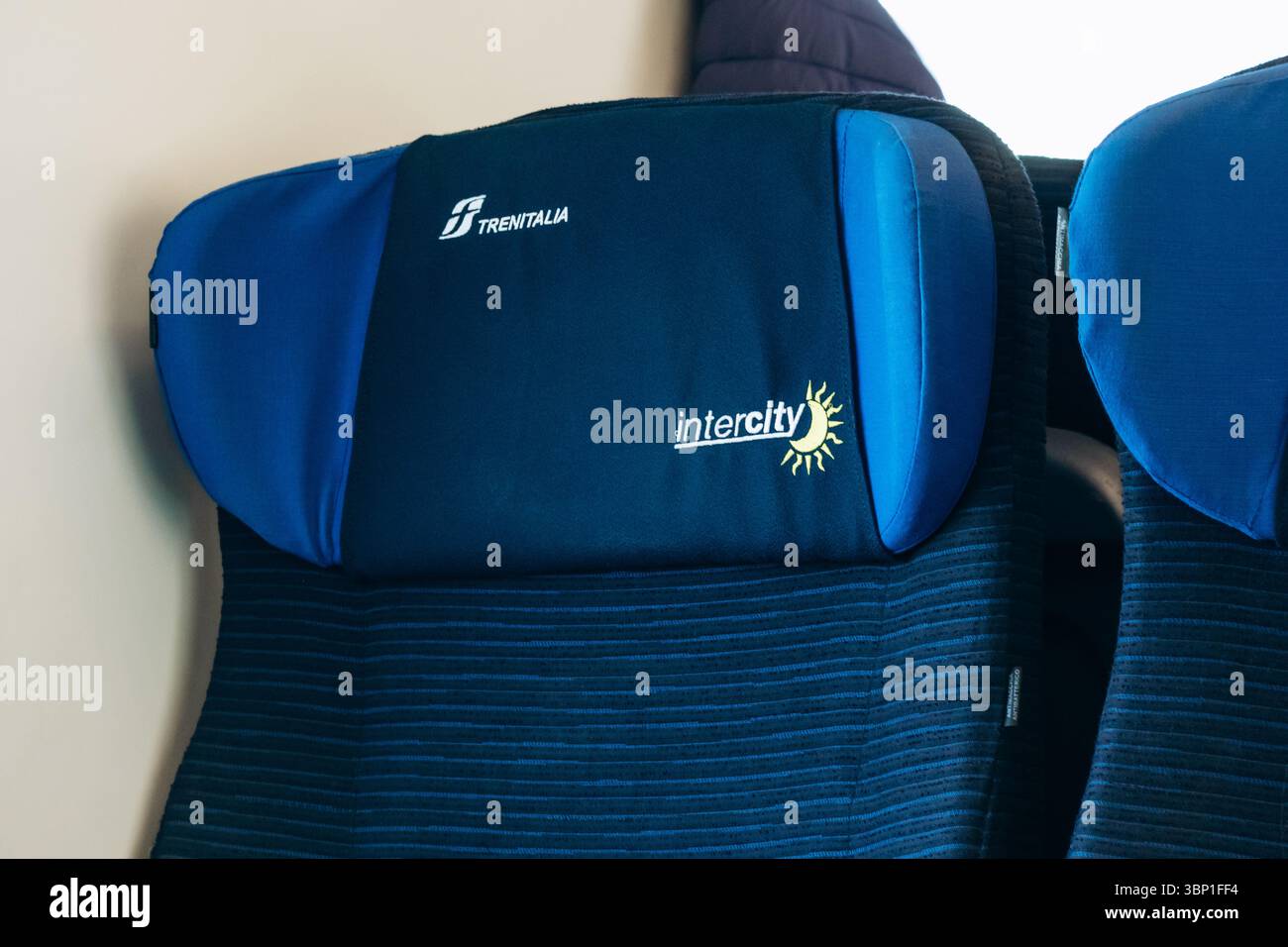 Mailand, Italien - 19. März 2025 : Nahaufnahme der blauen Triumalia Intercity-Zugsitze mit gestickten Logos für die Kopfstützen und Sonnenlicht, das durch den Wind kommt Stockfoto