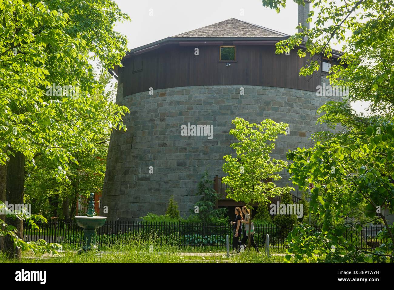 Rundsteinbefestigungsturm mit Verteidigungsmauern und grünem Laub Stockfoto