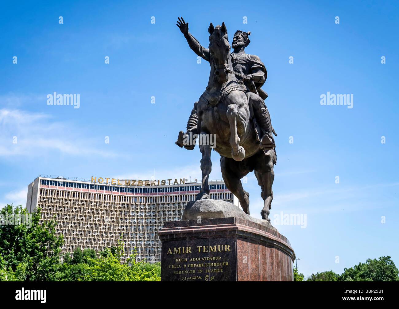 Eine Bronzestatue von Amir Temur zu Pferd, die eine Hand in einer Geste der Führung hebt. Die Statue steht vor einem klaren blauen Himmel, mit einem modernen heißen Himmel Stockfoto