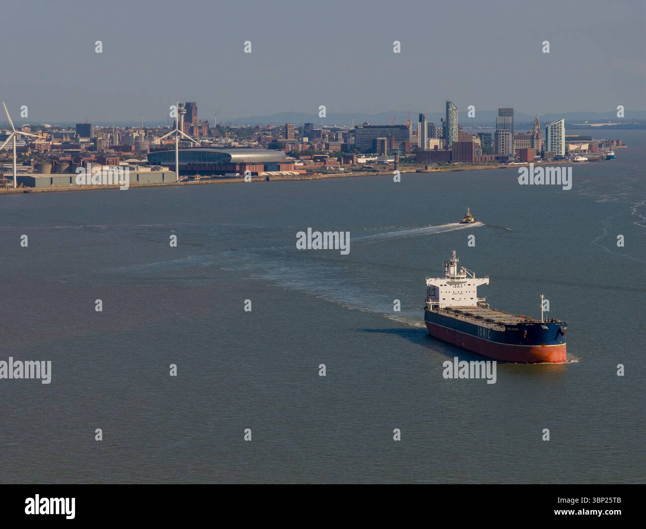 Luftbild eines Schiffes, das auf dem Fluss Mersey mit der Skyline von Liverpool City im Hintergrund unterwegs ist. Stockfoto