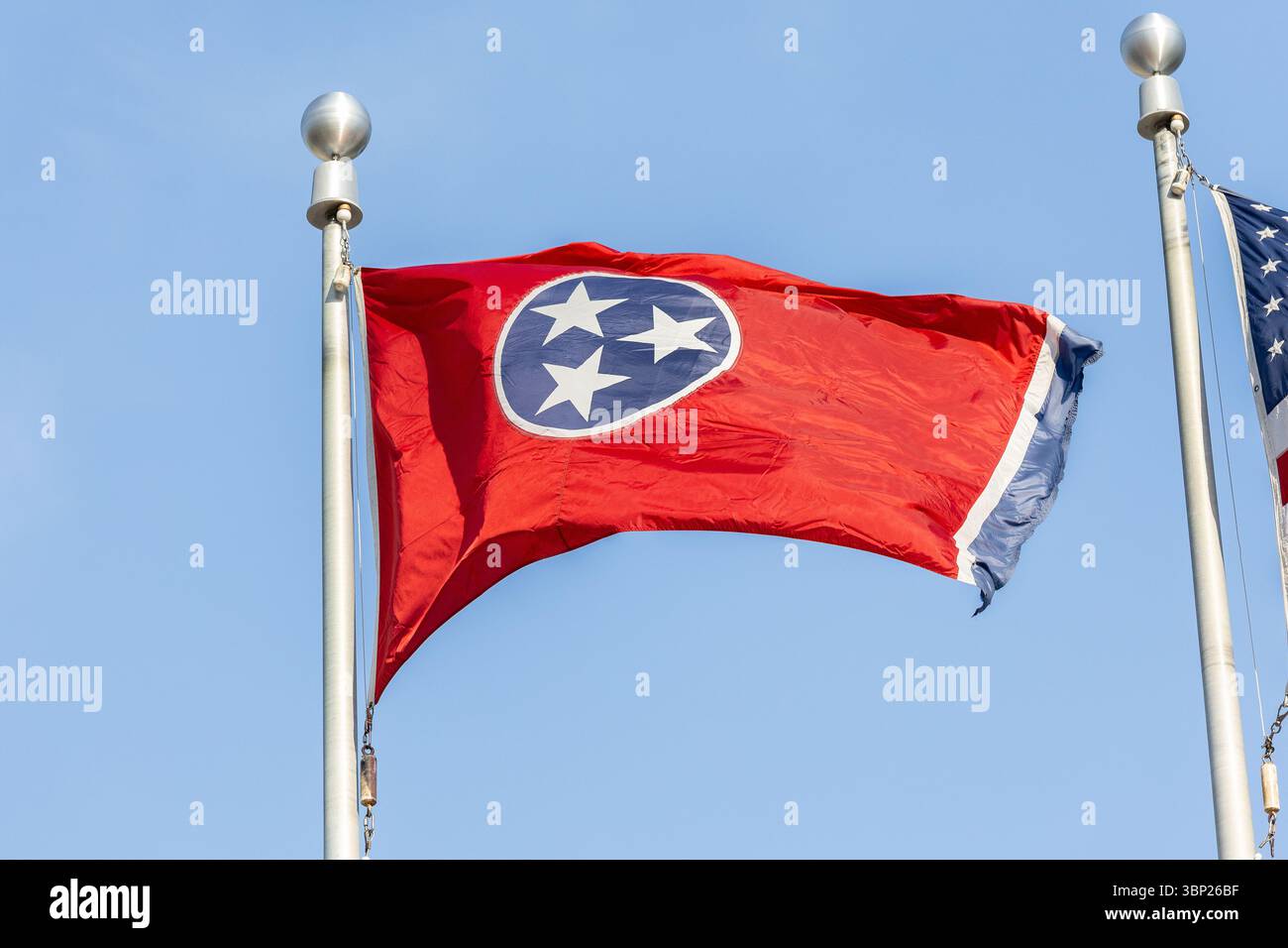 Die Bundesflagge von Tennessee auf einem im Wind wehenden Fahnenmast mit blauem Himmel. Stockfoto