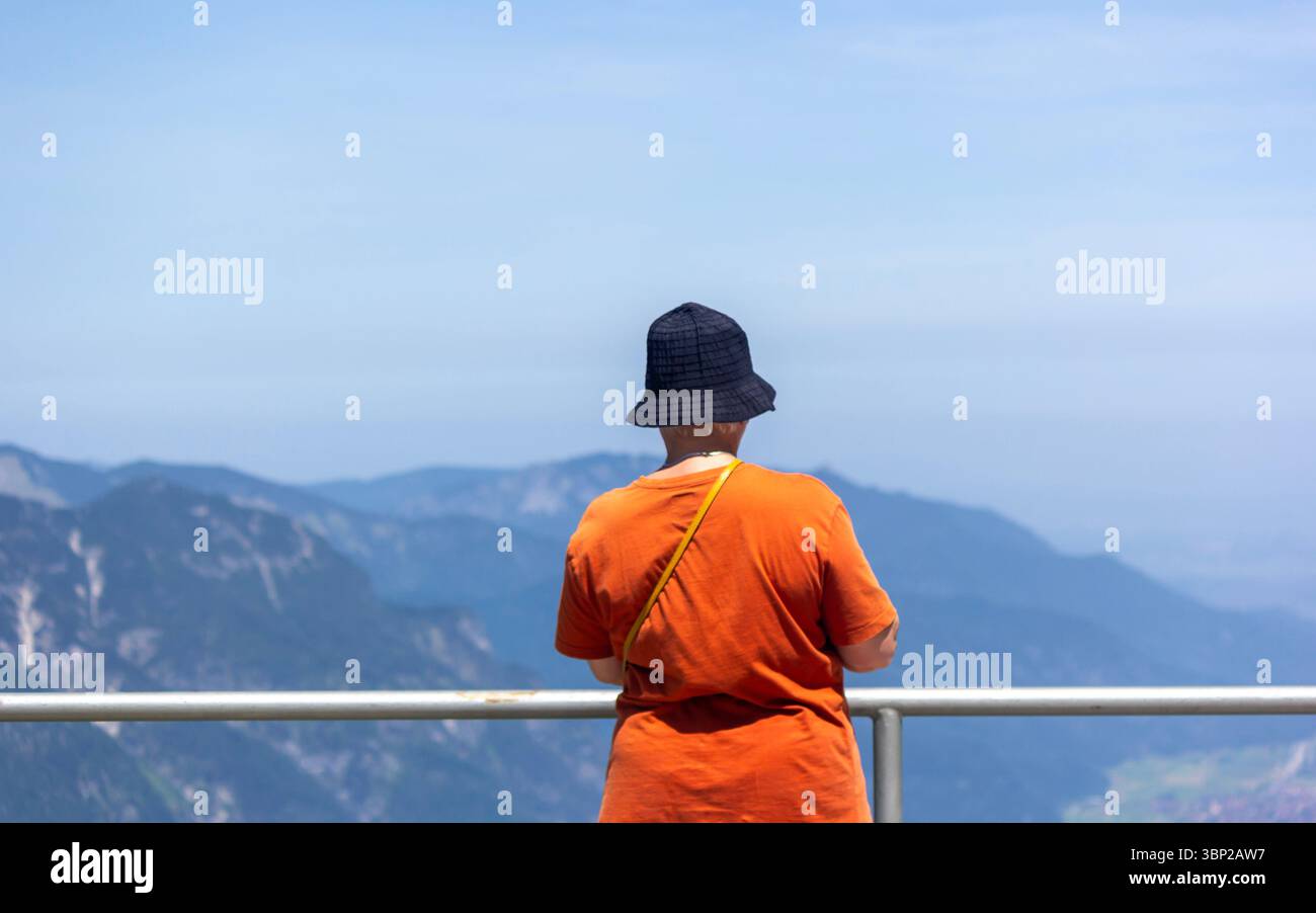 Ein Alleinreisender schaut bei sonnigem Sommerwetter auf die bayerischen Alpen Stockfoto