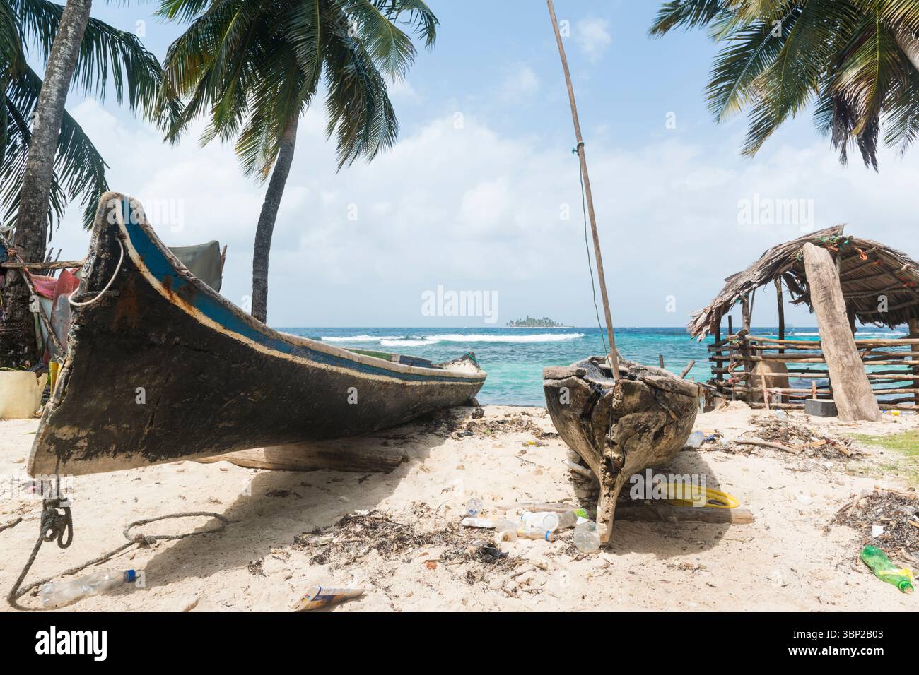 Zwei ausgegrabene Kanus am Strand einer Insel San Blas und Blick auf eine andere Insel in der Ferne. Schweinestall rechts. San Blas Archipel, Panama. Stockfoto