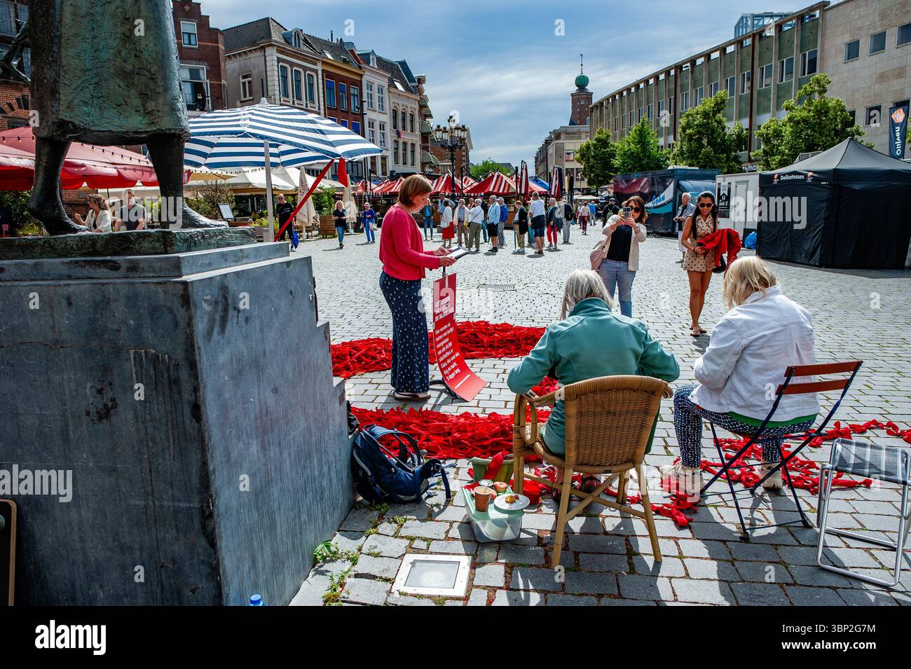 Nijmegen, Niederlande. Juli 2025. Zwei Touristen werden dabei beobachtet, wie sie Fotos von der Veranstaltung machen. In dieser Woche und bis morgen verlesen die Bewohner von Nijmegen Tag und Nacht die Namen der Menschen, die in Gaza gestorben sind; sowohl die israelischen Opfer vom 7. Oktober 2023 als auch die palästinensischen Opfer von damals und danach. Quelle: SOPA Images Limited/Alamy Live News Stockfoto
