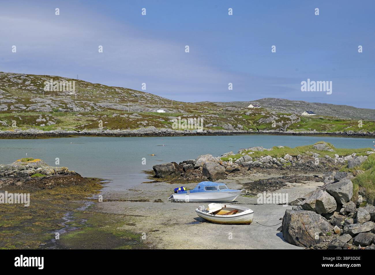 Zwei Boote an einem felsigen Ufer in einer ruhigen Bucht unter klarem Himmel vor Hügeln, Idyll, Äußere Hebriden, South Uist, Schottland, Großbritannien Stockfoto