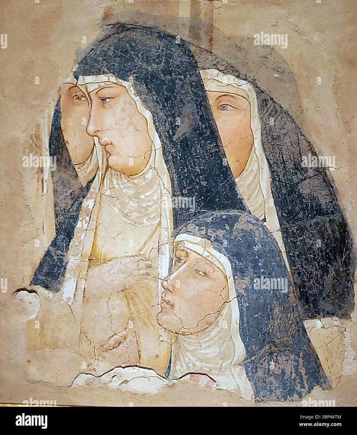 Eine Fotografie eines Freskenfragments mit dem Titel „A Group of Four Poor Clares“ von Ambrogio Lorenzetti, datiert um 1325 n. Chr. Ambrogio Lorenzetti, ein prominenter sienesischer Maler des 14. Jahrhunderts, war bekannt für seine bahnbrechenden Arbeiten zur Darstellung realistischer Figuren und räumlicher Tiefe. Die Klarinenser sind ein franziskanischer Orden kontemplativer Nonnen, der von der Heiligen Klara von Assisi gegründet wurde. Darstellungen religiöser Gestalten, vor allem aus den Betrügerorden, waren in der mittelalterlichen Kunst Italiens üblich, die oft für Klöster und Kirchen in Auftrag gegeben wurde. c. 1325. Stockfoto