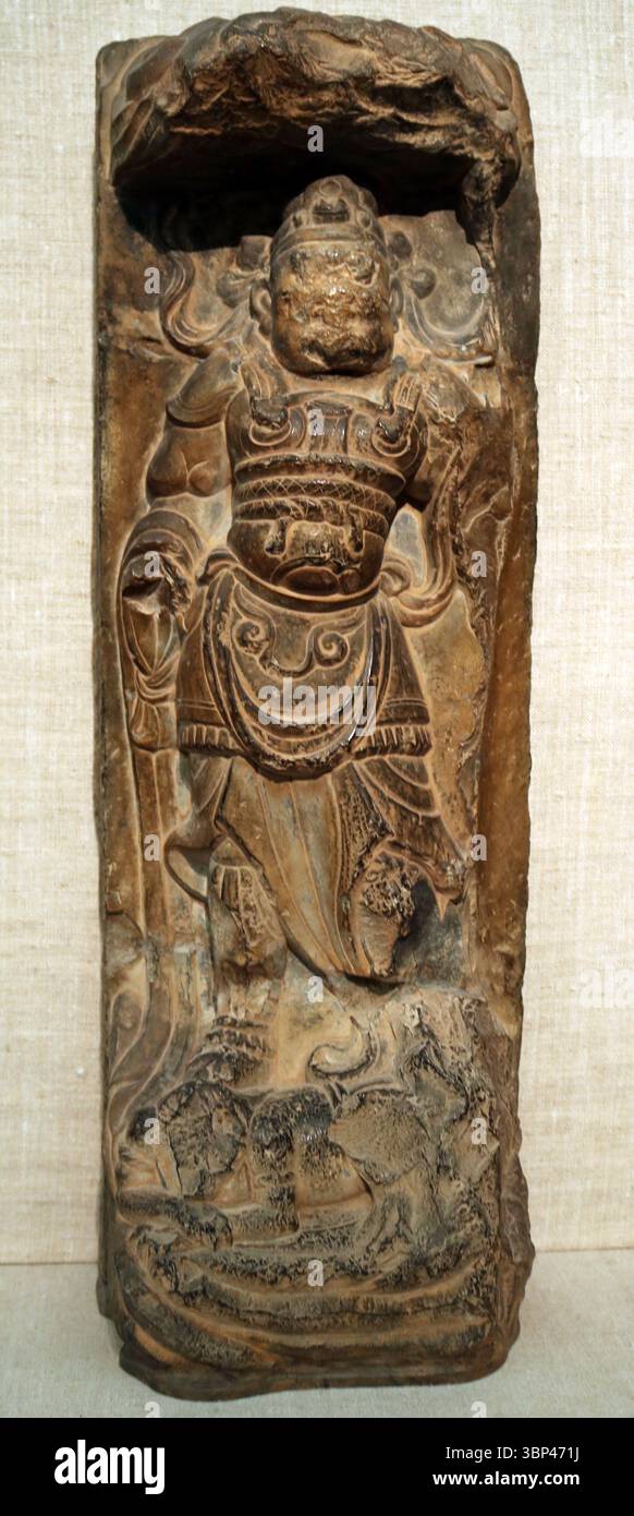 Geschnitzte Kalksteinreliefs eines Wächterkönigs, Tang Dynastie, China. Diese Schutzfiguren wurden typischerweise an den Eingängen von Tempeln platziert, um das Böse abzuwehren und den Dharma zu schützen. c. 700 CE. Stockfoto