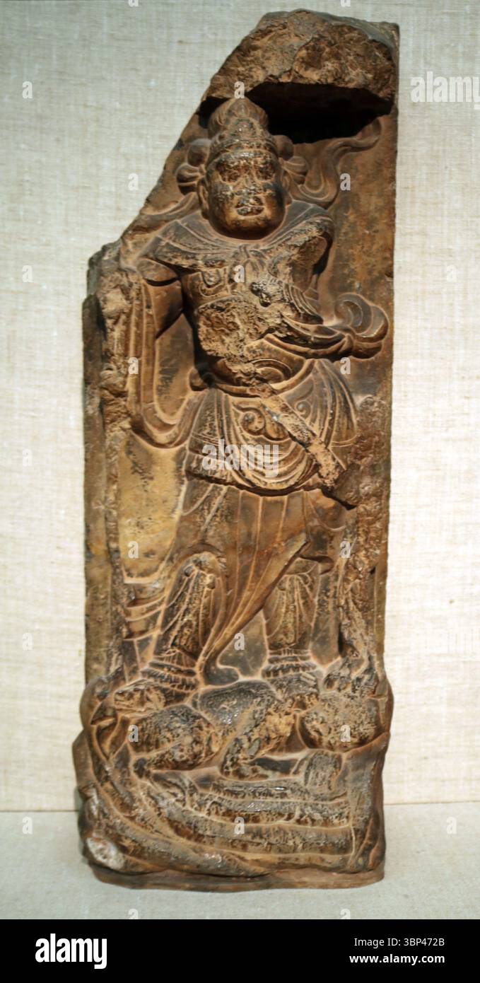 Geschnitzte Kalksteinreliefs eines Wächterkönigs, Tang Dynastie, China. Diese Schutzfiguren wurden typischerweise an den Eingängen von Tempeln platziert, um das Böse abzuwehren und den Dharma zu schützen. c. 700 CE. Stockfoto