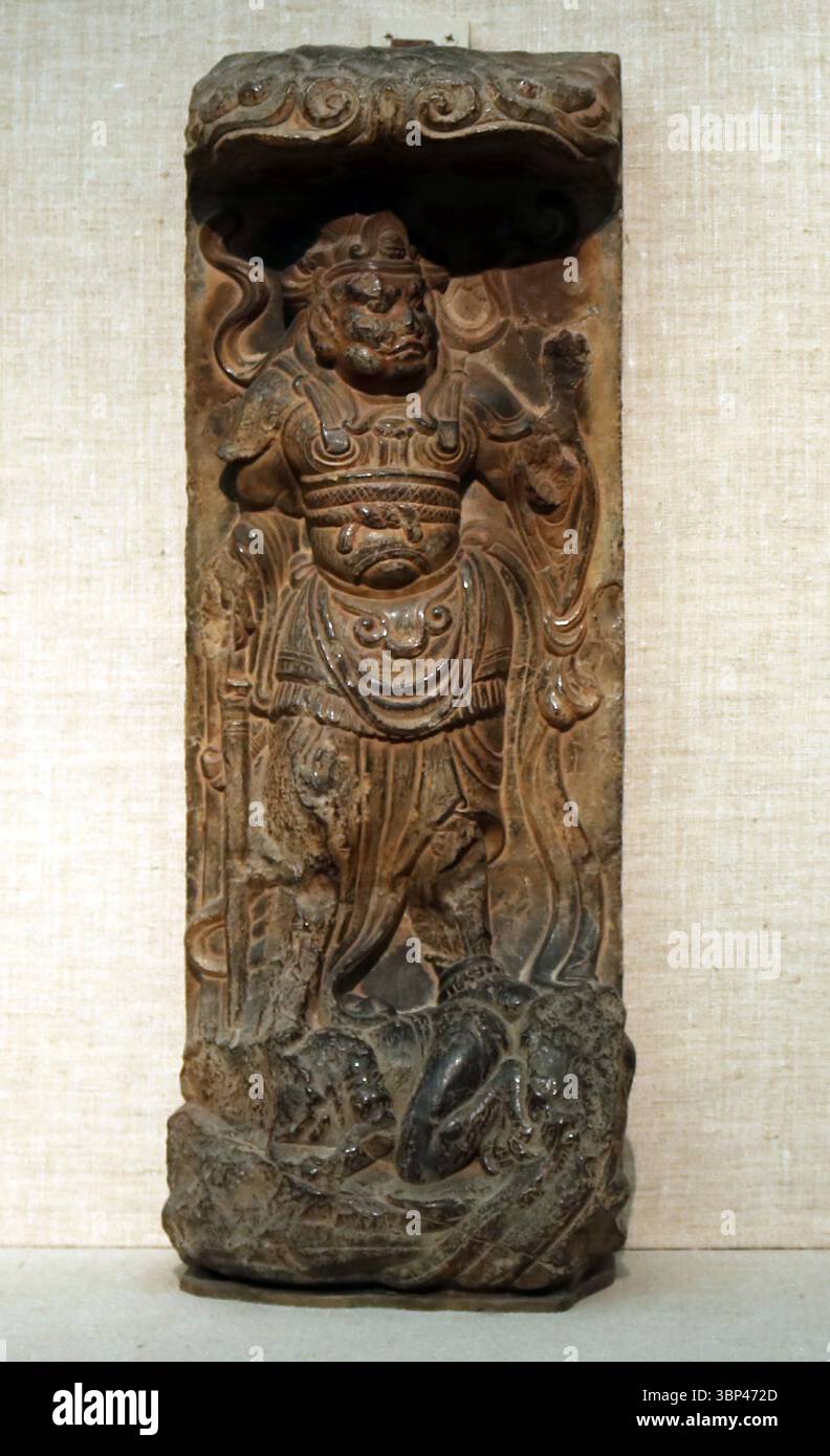 Geschnitzte Kalksteinreliefs eines Wächterkönigs, Tang Dynastie, China. Diese Schutzfiguren wurden typischerweise an den Eingängen von Tempeln platziert, um das Böse abzuwehren und den Dharma zu schützen. c. 700 CE. Stockfoto