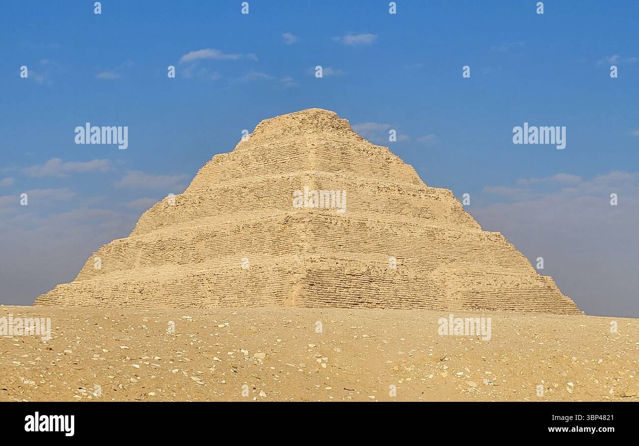 Eine Fotografie der Stufenpyramide von Djoser in Sakkara, Ägypten, die früheste monumentale Steinstruktur Ägyptens, erbaut für Pharao Djoser, um 2667 bis 2648 v. Chr. Die Pyramide ist das zentrale Merkmal eines riesigen Leichenkomplexes. Die Pyramide war ursprünglich 62,5 m (205 ft) hoch, mit einer Basis von 109 m ? 121 m (358 Fuß ? 397 ft) und war mit poliertem weißem Kalkstein verkleidet. Die Stufenpyramide (oder Proto-Pyramide) galt als die früheste großformatige Steinkonstruktion, die von Menschen aus dem Jahr 1997 gebaut wurde, obwohl die nahe gelegene Einfriedungsmauer „Gisr el-Mudir“ von einigen Ägyptologen vorgeschlagen wird, vor dem Komplex zu liegen. In Stockfoto