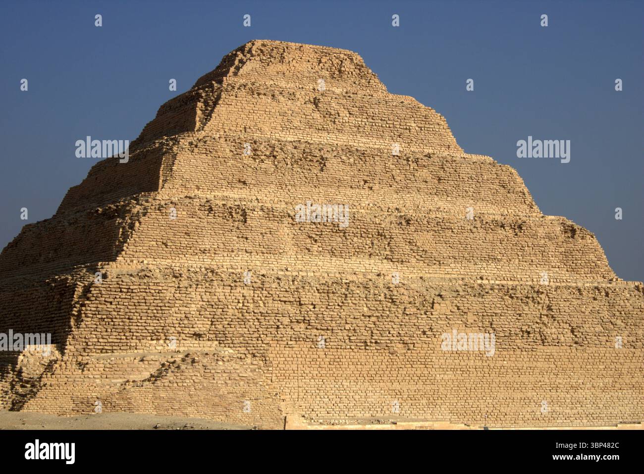 Eine Fotografie der Stufenpyramide von Djoser in Sakkara, Ägypten, die früheste monumentale Steinstruktur Ägyptens, erbaut für Pharao Djoser, um 2667 bis 2648 v. Chr. Die Pyramide ist das zentrale Merkmal eines riesigen Leichenkomplexes. Die Pyramide war ursprünglich 62,5 m (205 ft) hoch, mit einer Basis von 109 m ? 121 m (358 Fuß ? 397 ft) und war mit poliertem weißem Kalkstein verkleidet. Die Stufenpyramide (oder Proto-Pyramide) galt als die früheste großformatige Steinkonstruktion, die von Menschen aus dem Jahr 1997 gebaut wurde, obwohl die nahe gelegene Einfriedungsmauer „Gisr el-Mudir“ von einigen Ägyptologen vorgeschlagen wird, vor dem Komplex zu liegen. In Stockfoto
