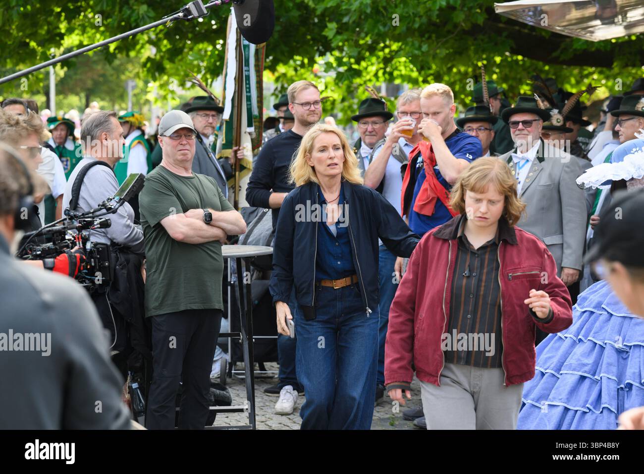 Hannover, Deutschland. Juli 2025. Die Schauspielerinnen Maria Furtwängler (Mitte) und Luise von Stein (rechts) spielen während der Dreharbeiten eine Szene für einen neuen fiktiven Tatort mitten im echten Schützenausmarsch am Neuen Rathaus. Nach Angaben des Norddeutschen Rundfunks (NDR) begannen während des Schützenausmarsches die Dreharbeiten für einen neuen Tatort: Schützenfest mit Maria Furtwängler als Inspektorin Charlotte Lindholm. Quelle: Julian Stratenschulte/dpa/Alamy Live News Stockfoto