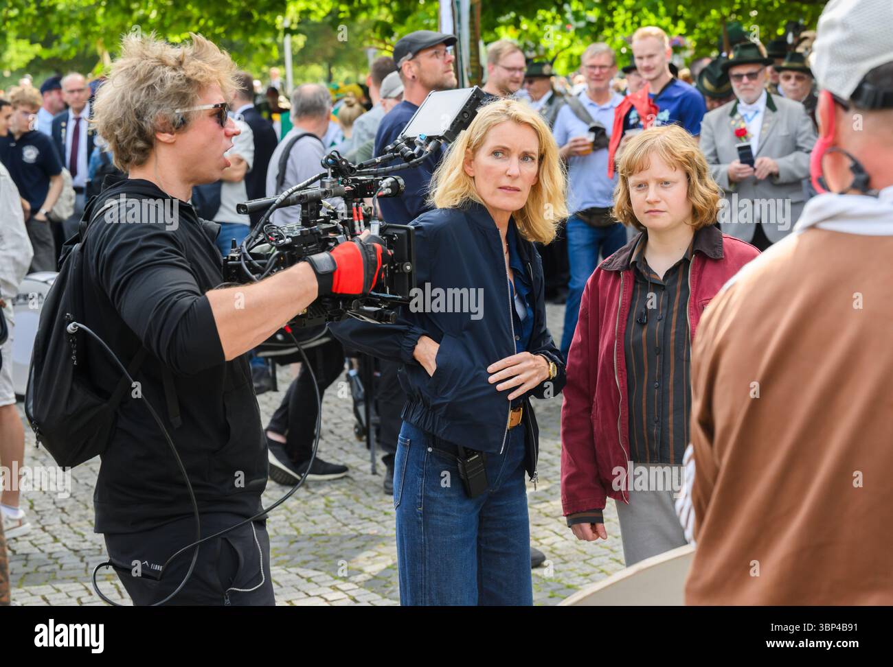 Hannover, Deutschland. Juli 2025. Die Schauspielerinnen Maria Furtwängler (l) und Luise von Stein spielen während der Dreharbeiten für einen neuen fiktiven Tatort mitten im echten Schützenausmarsch am Neuen Rathaus eine Szene. Nach Angaben des Norddeutschen Rundfunks (NDR) begannen während des Schützenausmarsches die Dreharbeiten für einen neuen Tatort: Schützenfest mit Maria Furtwängler als Kommissarin Charlotte Lindholm. Quelle: Julian Stratenschulte/dpa/Alamy Live News Stockfoto