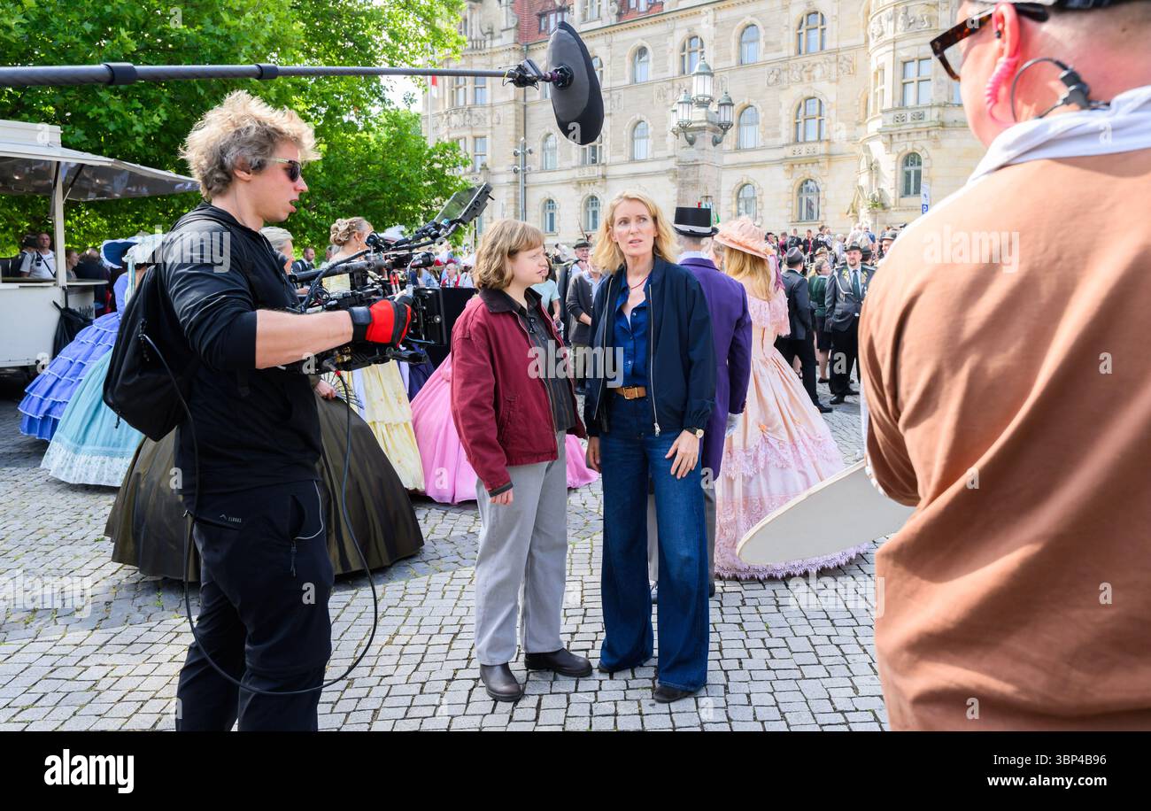 Hannover, Deutschland. Juli 2025. Die Schauspielerinnen Maria Furtwängler (r) und Luise von Stein spielen während der Dreharbeiten eine Szene für einen neuen fiktiven Tatort mitten im echten Schützenausmarsch am Neuen Rathaus. Nach Angaben des Norddeutschen Rundfunks (NDR) begannen während des Schützenausmarsches die Dreharbeiten für einen neuen Tatort: Schützenfest mit Maria Furtwängler als Kommissarin Charlotte Lindholm. Quelle: Julian Stratenschulte/dpa/Alamy Live News Stockfoto