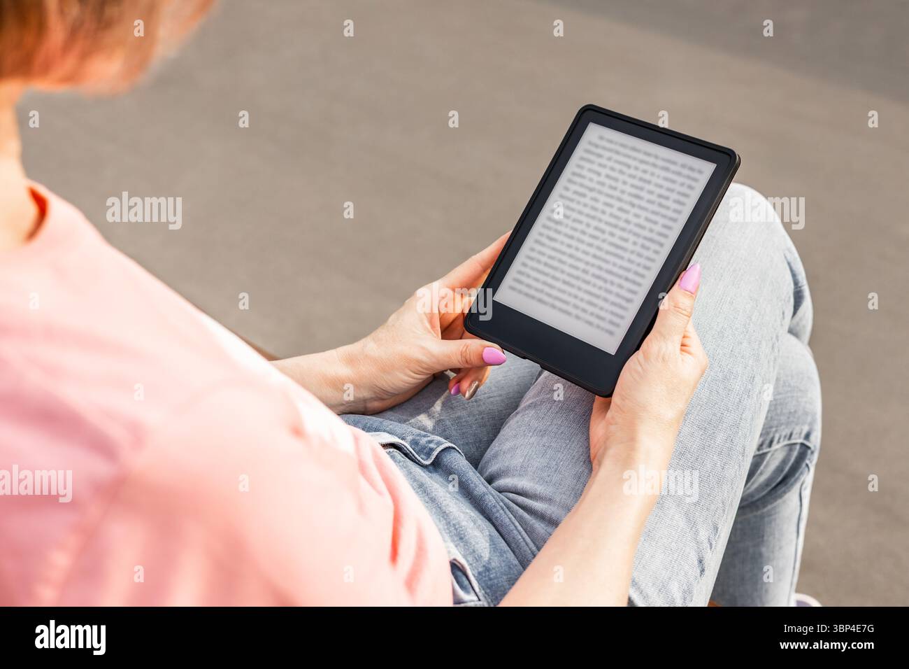 Frau, die E-Book liest, sitzt auf der Bank, Nahaufnahme. Stockfoto