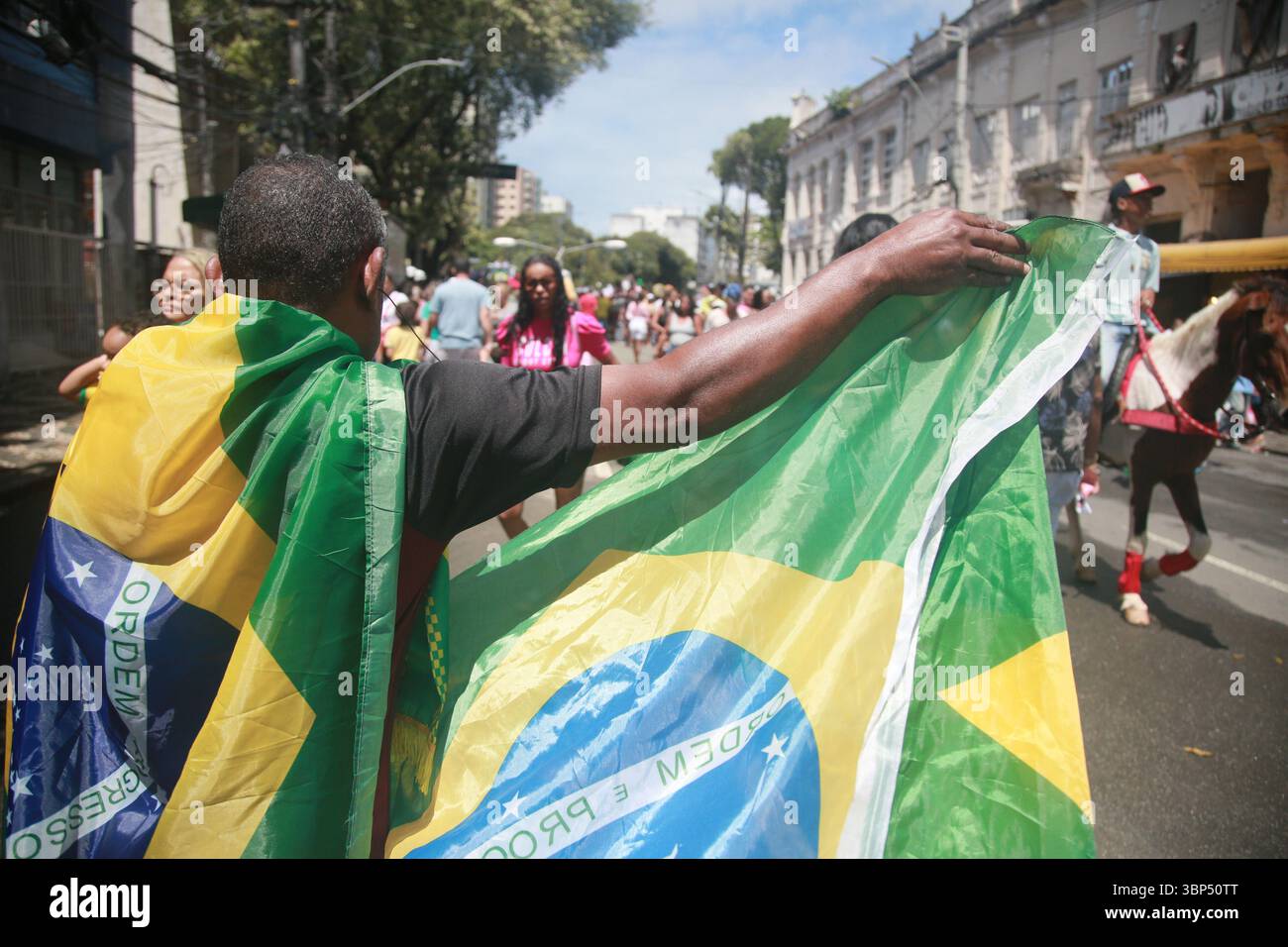 salvador, bahia, brasilien - 7. september 2023: Der Mann hält die brasilianische Flagge während einer Bürgerparade zum brasilianischen Unabhängigkeitstag. Stockfoto