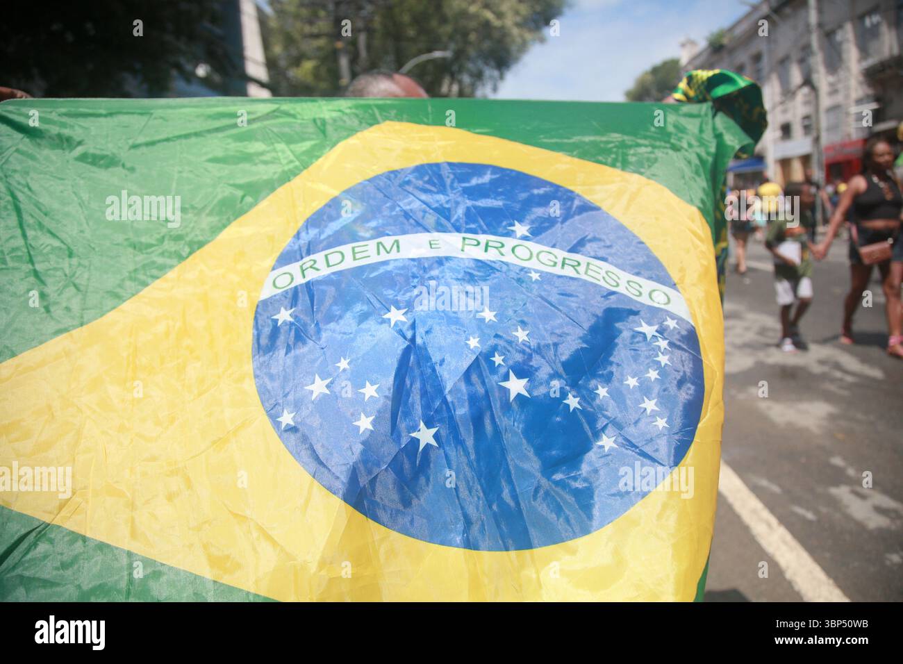 salvador, bahia, brasilien - 7. september 2023: Der Mann hält die brasilianische Flagge während einer Bürgerparade zum brasilianischen Unabhängigkeitstag. Stockfoto
