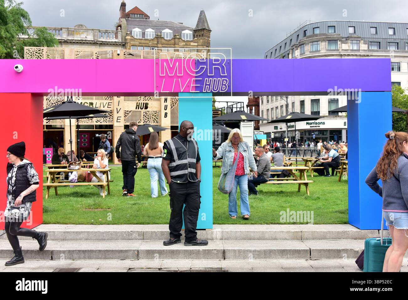 MCR Live Hub '25 in Piccadilly Gardens, Manchester, Großbritannien. Organisatoren sagen: „Am Freitag, dem 4. Juli, wurde der MCR Live Hub in den Piccadilly Gardens offiziell eröffnet, der neben Drinks und Eats auch ein Programm mit Live-Musik und DJs auf seiner Bühne während des Sommers verspricht.“ Dies ist Teil eines Sommers mit Musikveranstaltungen und Kunstwerken im Stadtzentrum von Manchester. Stockfoto