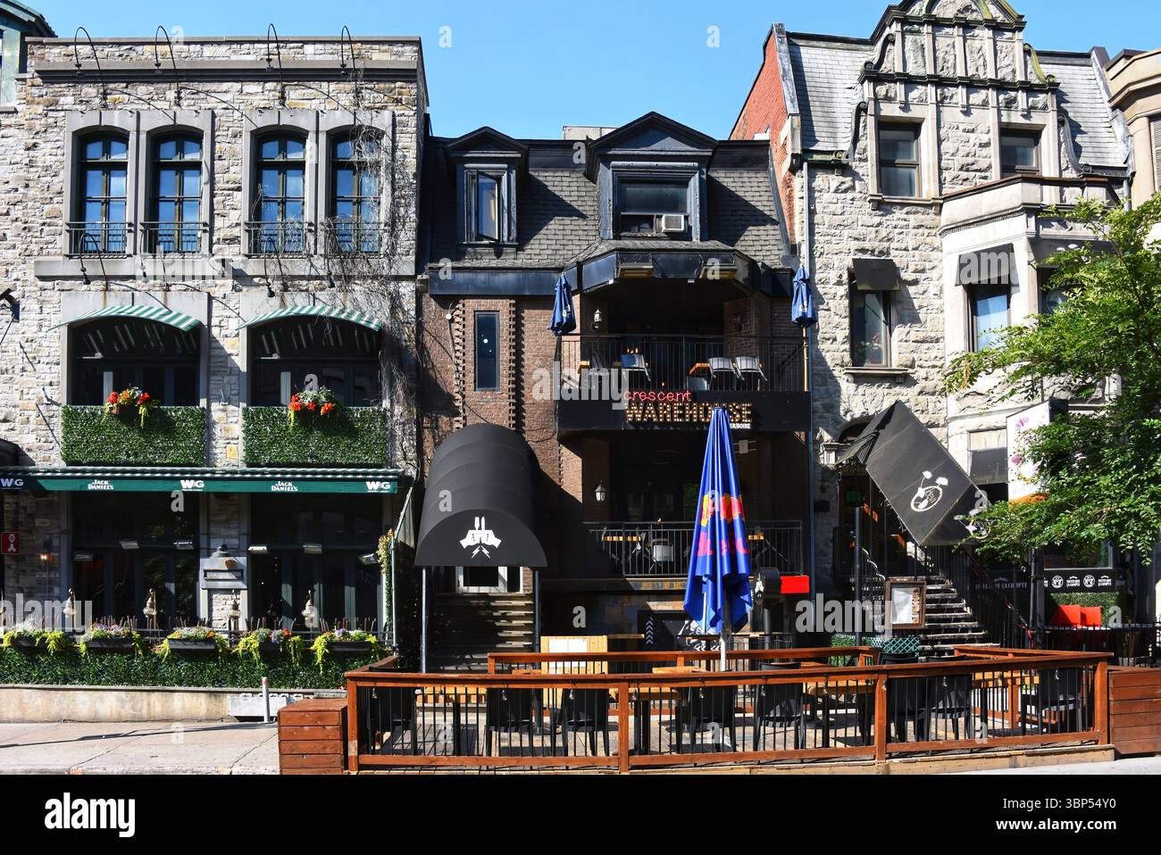 Montreal, Kanada - 30. Juni 2025: Das Warehouse auf der trendigen Crescent Street in Montreal mit einer Terrasse auf Straßenebene. Das Warehouse Restaurant beginnt Stockfoto