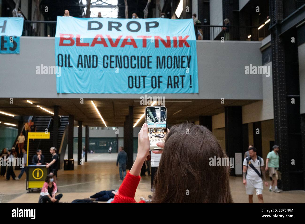 London, Großbritannien. 6. Juli 2025. Klimaaktivisten „Climate Resistance“ inszenierten in der Turbinenhalle der Tate Modern einen Sterbeprotest und forderten, dass das Museum die Beziehungen zum Milliardär Len Blavatnik abbricht. Zwei große Banner, die von einem Balkon aufgerollt wurden, lauteten: "Billionäre abschaffen" und "Blavatnik-Öl und Völkermord-Geld aus der Kunst werfen!" Der Protest zielte darauf ab, dass das Museum Gelder von Blavatnik, einem Ölmagnaten, entgegennahm, der auch mit Israel und dem Zionismus verbunden ist. Anrede: Andrea Domeniconi/Alamy Live News Stockfoto