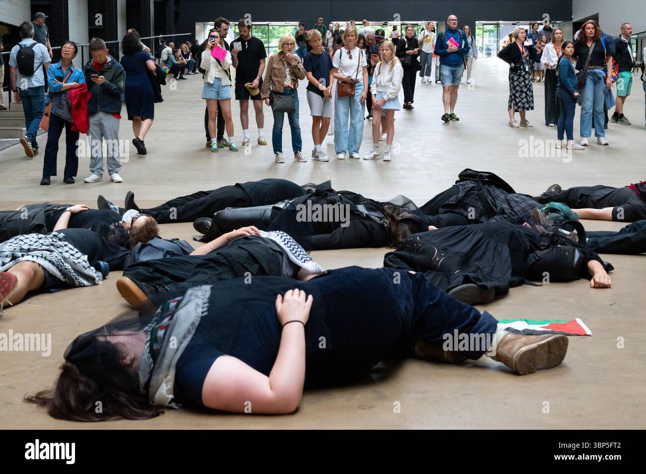 London, Großbritannien. 6. Juli 2025. Klimaaktivisten „Climate Resistance“ inszenierten in der Turbinenhalle der Tate Modern einen Sterbeprotest und forderten, dass das Museum die Beziehungen zum Milliardär Len Blavatnik abbricht. Zwei große Banner, die von einem Balkon aufgerollt wurden, lauteten: "Billionäre abschaffen" und "Blavatnik-Öl und Völkermord-Geld aus der Kunst werfen!" Der Protest zielte darauf ab, dass das Museum Gelder von Blavatnik, einem Ölmagnaten, entgegennahm, der auch mit Israel und dem Zionismus verbunden ist. Anrede: Andrea Domeniconi/Alamy Live News Stockfoto