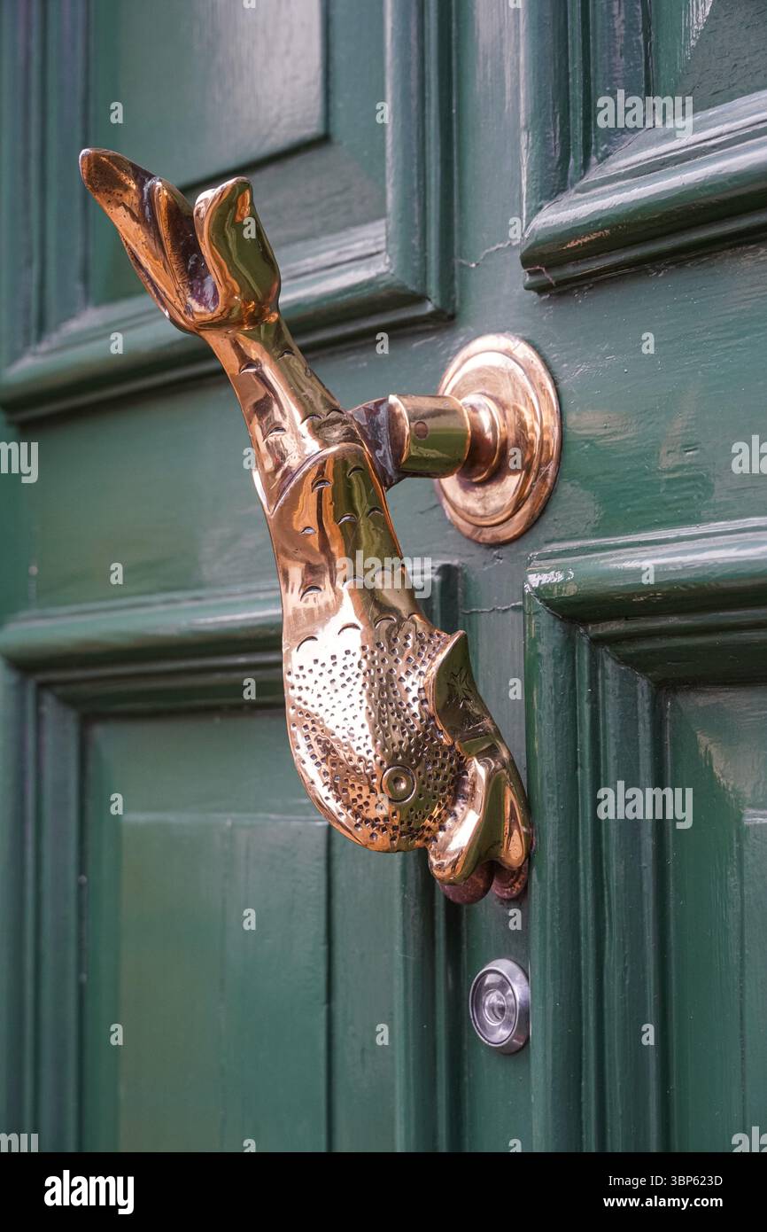 Fischförmiger Messingklopfer an einer grünen Tür, London England Vereinigtes Königreich Großbritannien Stockfoto