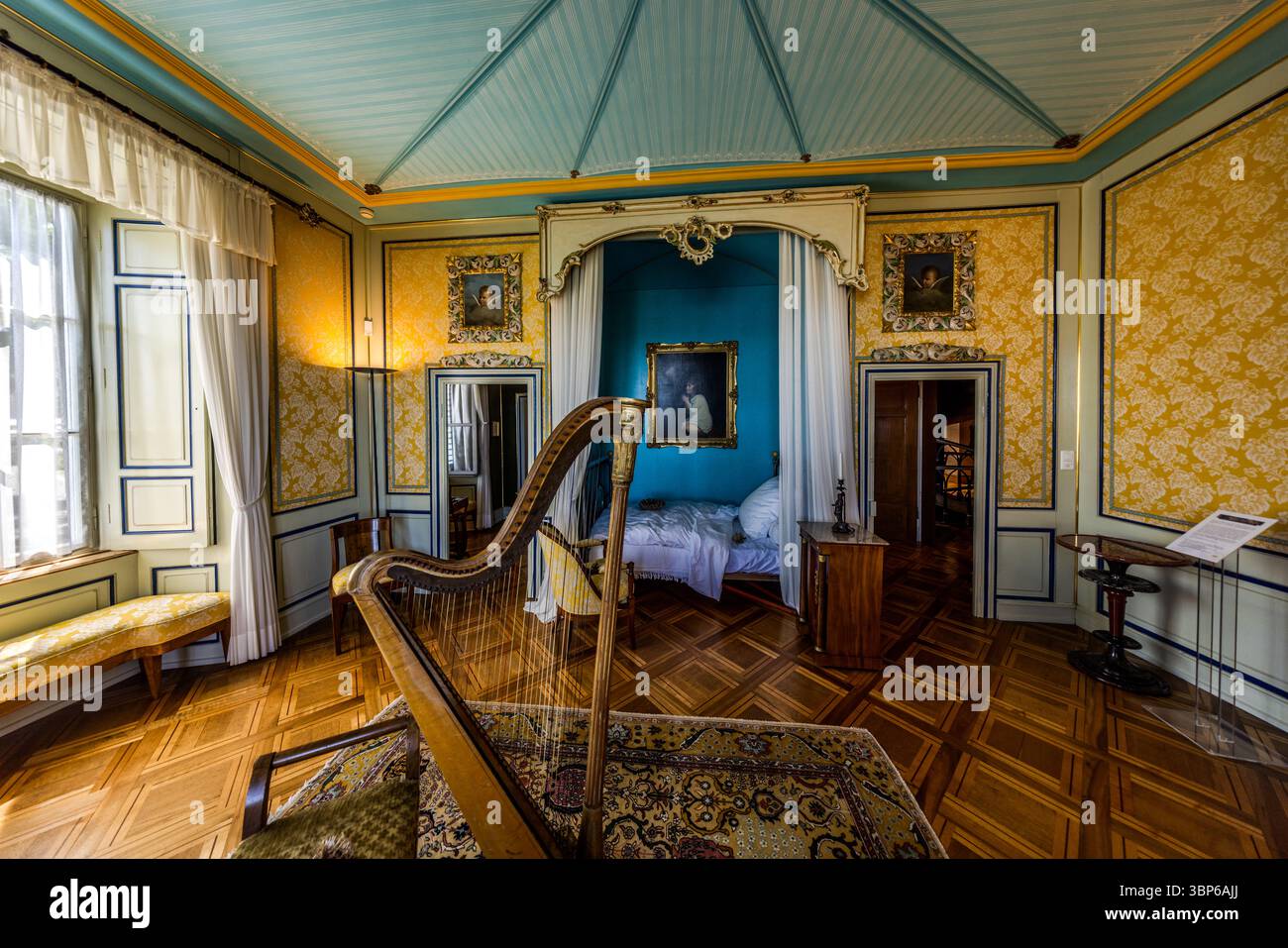 Zimmer im Napoleon Museum mit Himmelbett, Harfe und anderen Möbeln. Gelbe Tapete bedeckt die Wände. Die Decke ist blau gestreift. Salenstein, Arenenberg, Thurgau, Schweiz, Europa Stockfoto