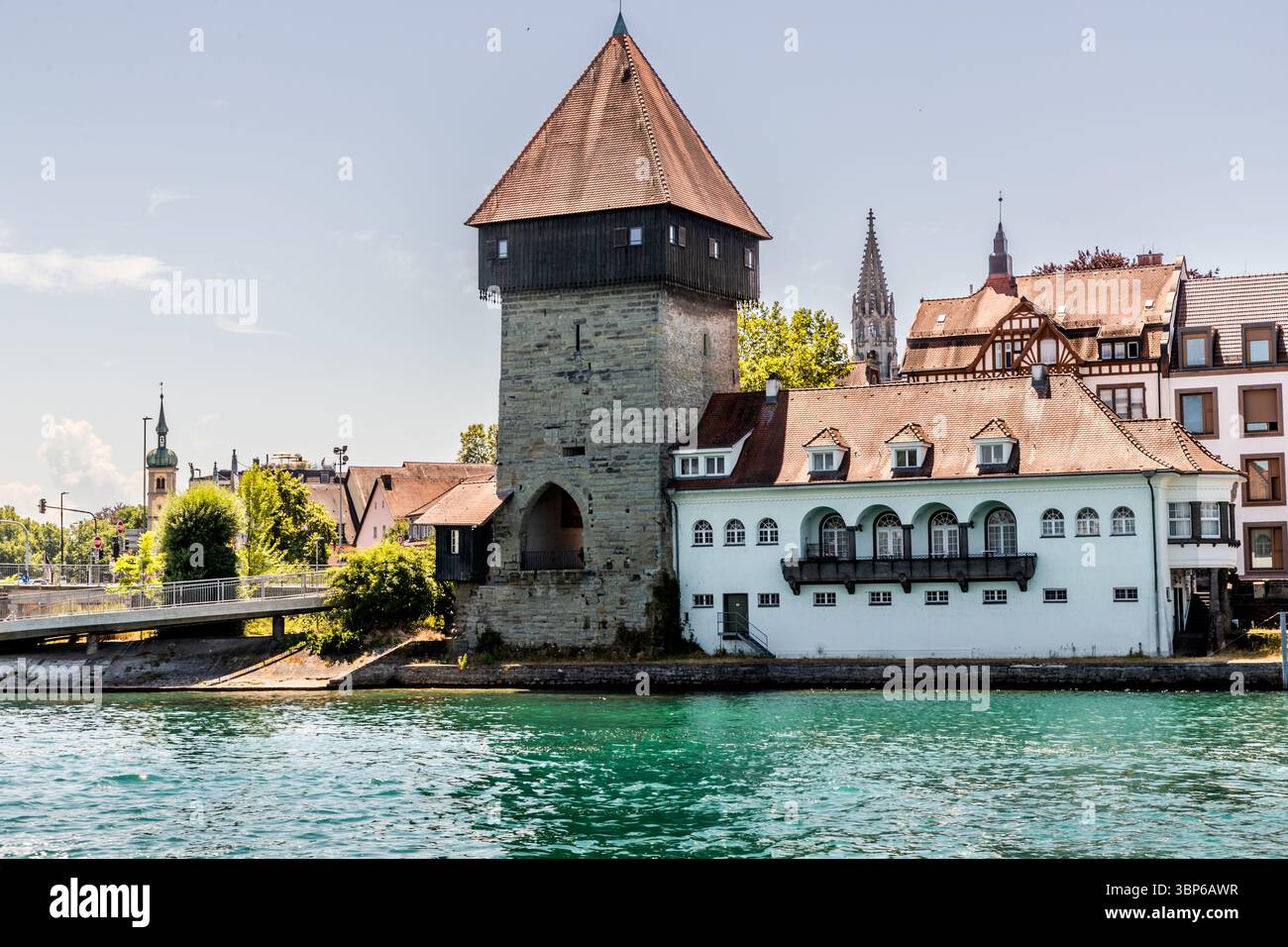 Der Rheintorturm und ein dazugehöriges Bauwerk am Rhein in Konstanz, Baden-Württemberg. Weitere Gebäude und eine Brücke sind im Hintergrund zu sehen. Konstanz, Baden-Württemberg, Deutschland Stockfoto