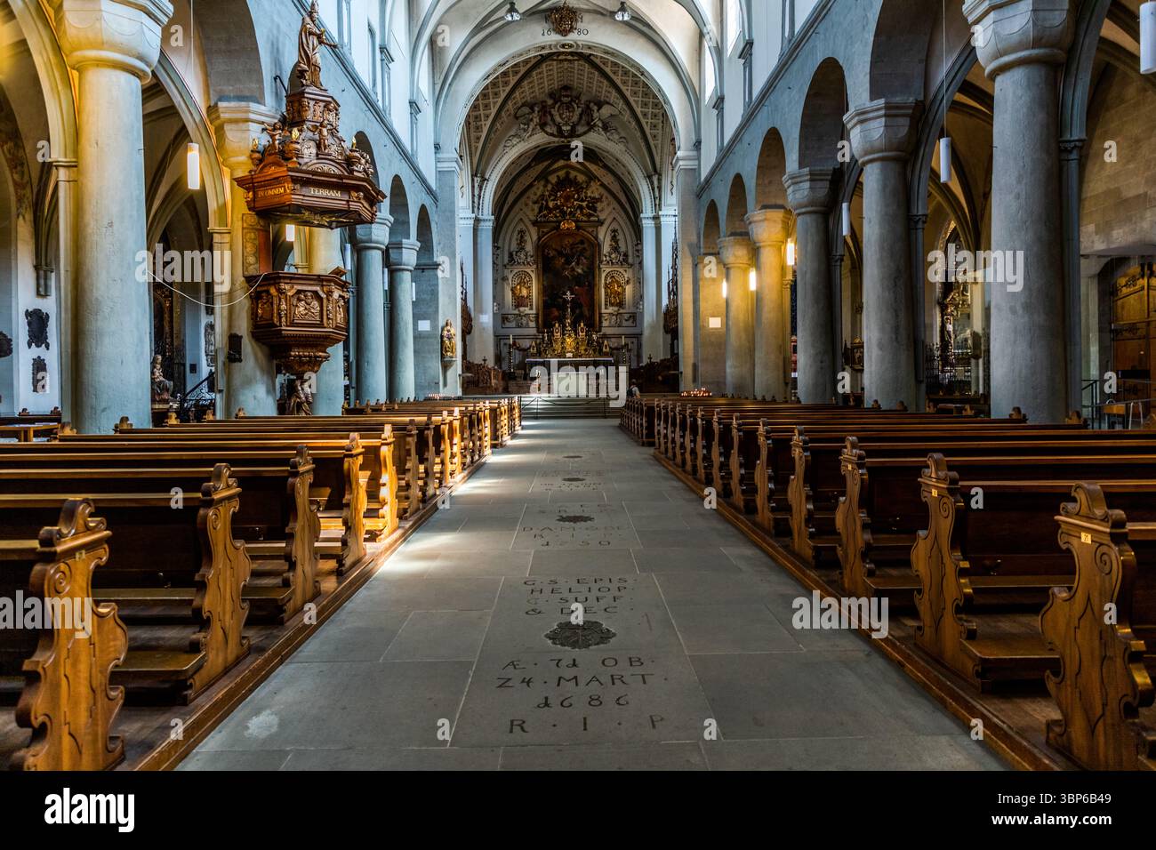 Innenansicht des Konstanzer Münsters. Holzbänke säumen den Mittelgang. Eine Kanzel steht links im Kirchenschiff. Der Boden ist mit Grabplatten bedeckt. Münsterplatz, Konstanz, Baden-Württemberg, Deutschland Stockfoto