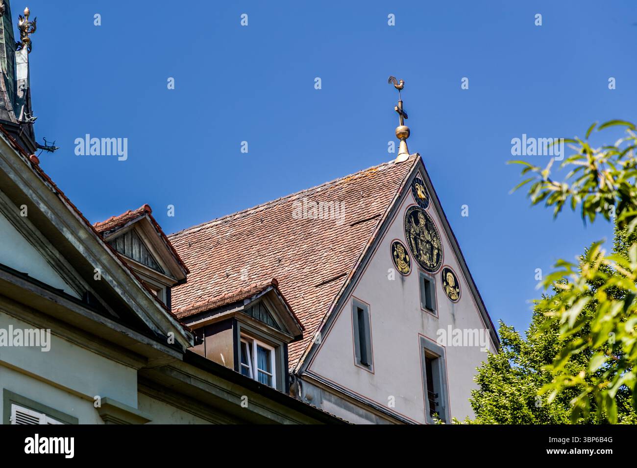 Dach und Giebeldach des Konstanzer Münsters. Der Giebel ist mit goldenen Reliefs und einem Wetterhahn verziert. Vier feuervergoldete Kupferscheiben prangten von 1300 bis 1925 auf dem äußeren Ostgiebel des zum See hin gerichteten Chors. (Kopien sind dort seit 1973 ausgestellt)..Hofhalde, Konstanz, Baden-Württemberg, Deutschland Stockfoto