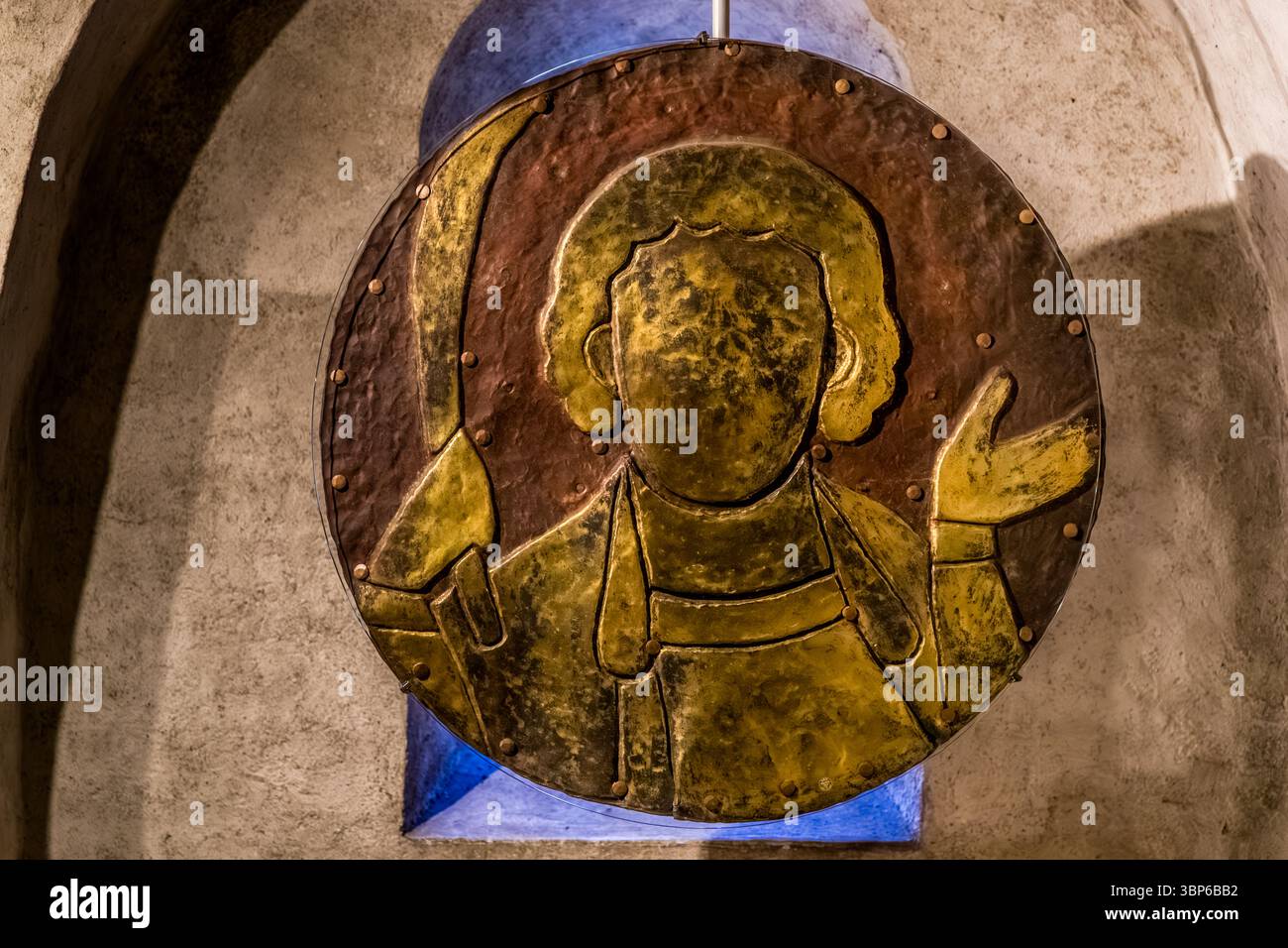 Die Originale der goldenen Medaillons befinden sich in der Krypta des Konstanzer Doms. Ein rundes Relief aus Metall zeigt eine stilisierte Figur, die ein Objekt hält und eine Hand hebt. Theatergasse, Konstanz, Baden-Württemberg, Deutschland Stockfoto