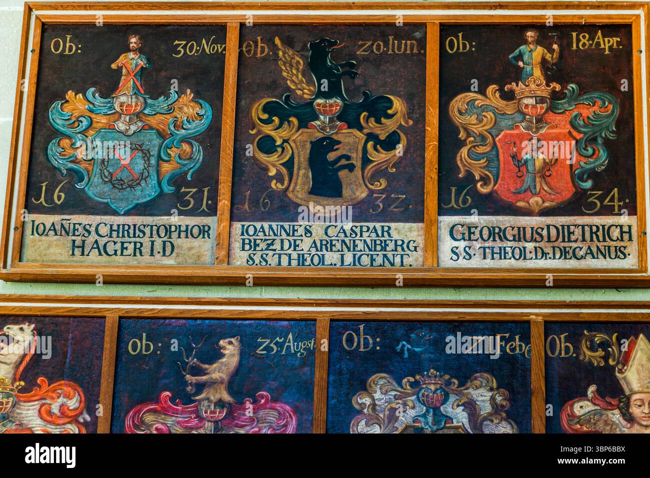Drei bemalte Holztafeln im Konstanzer Münster zeigen die Wappen und Namen verstorbener Personen: Ioanes Christophor Hager (gestorben am 30. November 1631), Ioannes Caspar Bez de Arenenberg (gestorben am 20. Juni 1632) und Georgius Dietrich, Doktor der Theologie und Dekan (gestorben am 18. April 1634). Die Tafeln sind Teil einer Serie von Epitaphen im Münster. Theatergasse, Konstanz, Baden-Württemberg, Deutschland. Stockfoto