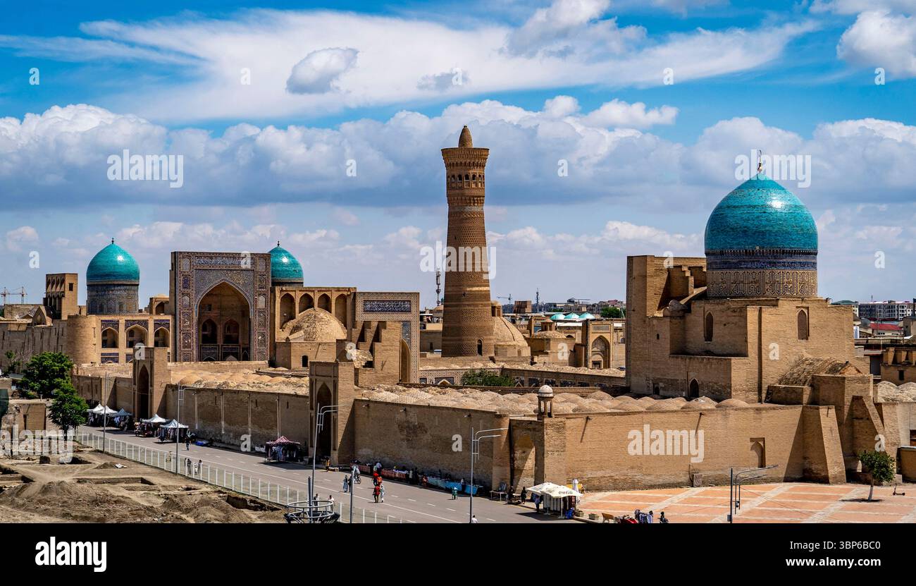 Ein Panoramablick auf die historische Architektur in Buchara, Usbekistan, mit Kuppelbauten mit türkisfarbenen Dächern, einem hohen Minarett und alten Mauern u Stockfoto
