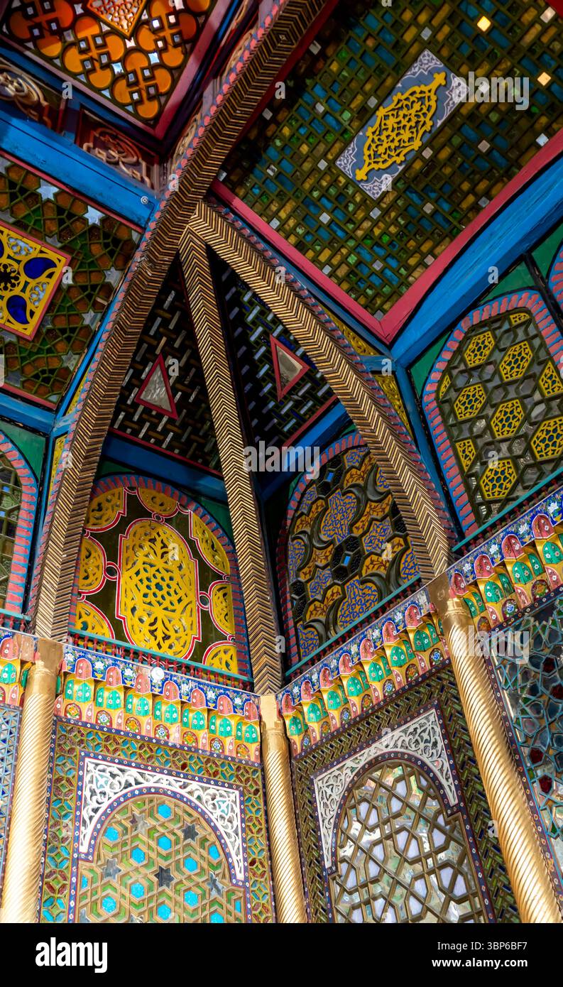 Eine lebendige und aufwendig gestaltete Decke mit farbenfrohen geometrischen Mustern und verzierten Details. Die Architektur zeigt eine Mischung aus Kultur Stockfoto