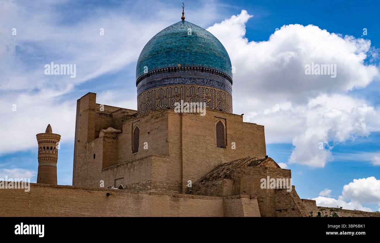 Ein atemberaubender Blick auf eine alte architektonische Struktur mit einer großen blauen Kuppel und komplizierten Designs vor dem Hintergrund flauschiger weißer Wolken Stockfoto