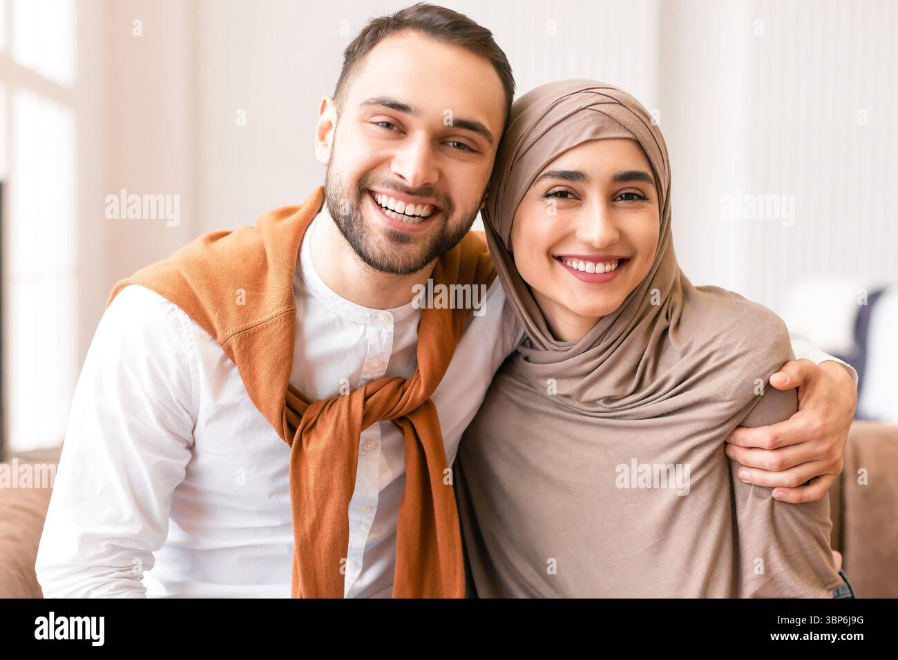 Happy Muslim Paar Umarmt Sitzen Zusammen Auf Der Couch Zu Hause Stockfoto